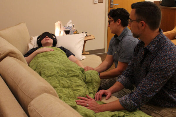 Health practitioners assess a patient during a psilocybin treatment session.